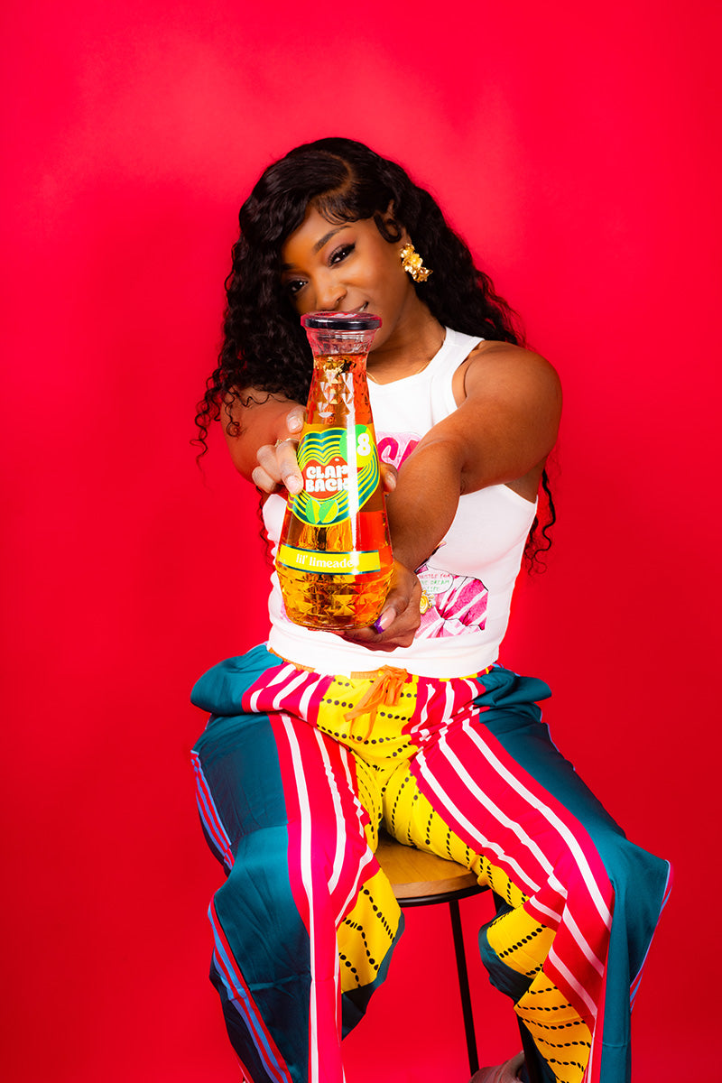 Person holding a bottle with a red background