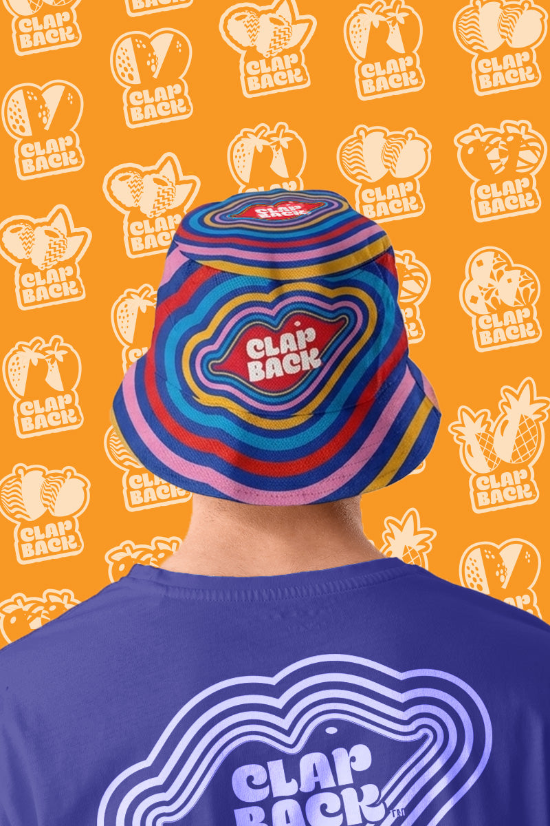 Person wearing a colorful bucket hat and t-shirt with ClapBack logo on an orange background with brand logo.