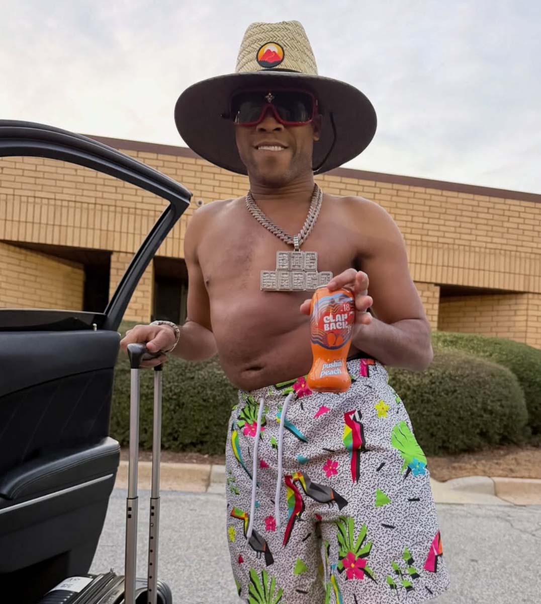 Man holding a bottle of ClapBack pushin peach wearing vacation attire
