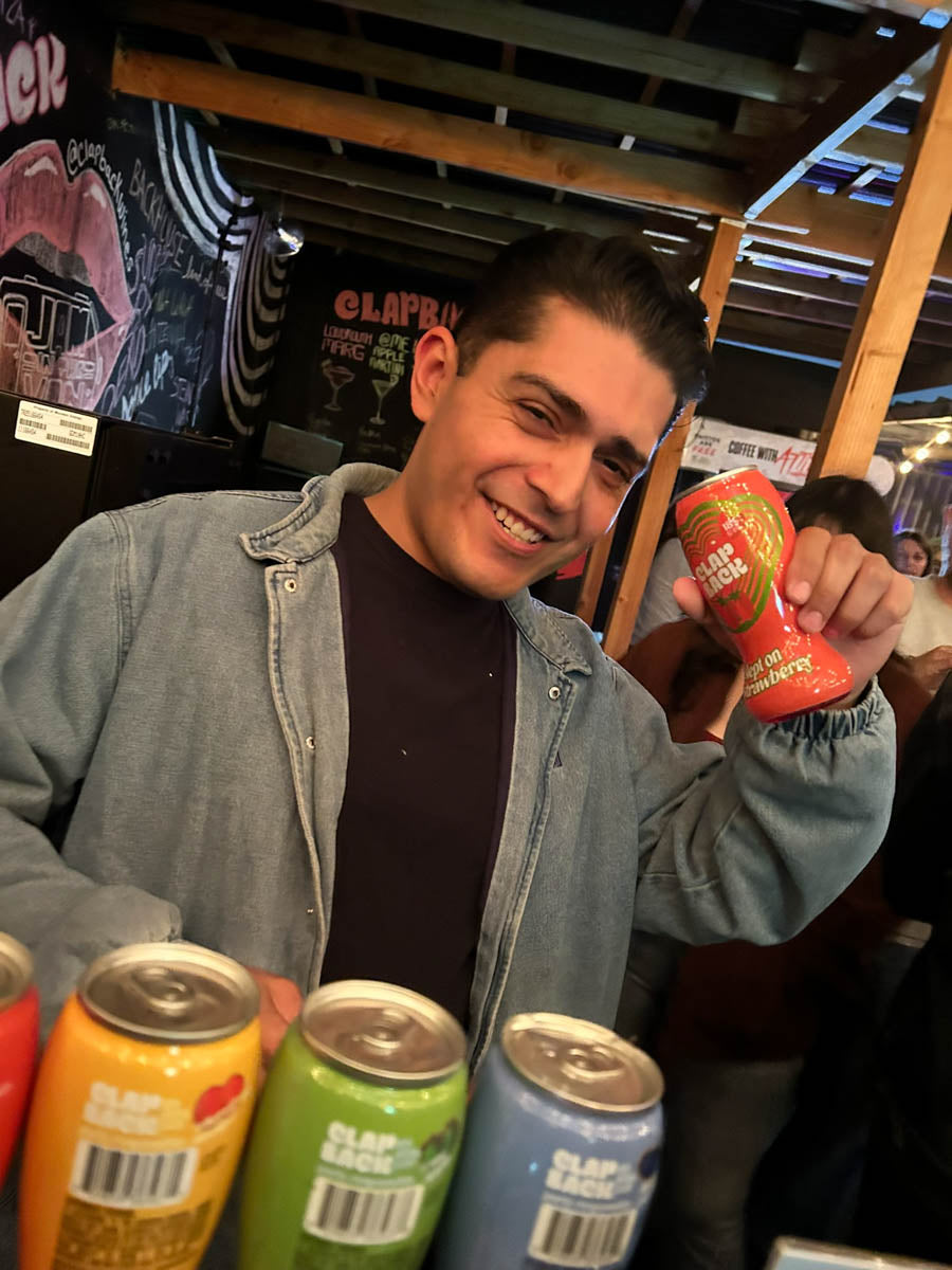 Man holding a can of ClapBack slept on strawberry grape wine in a casual setting
