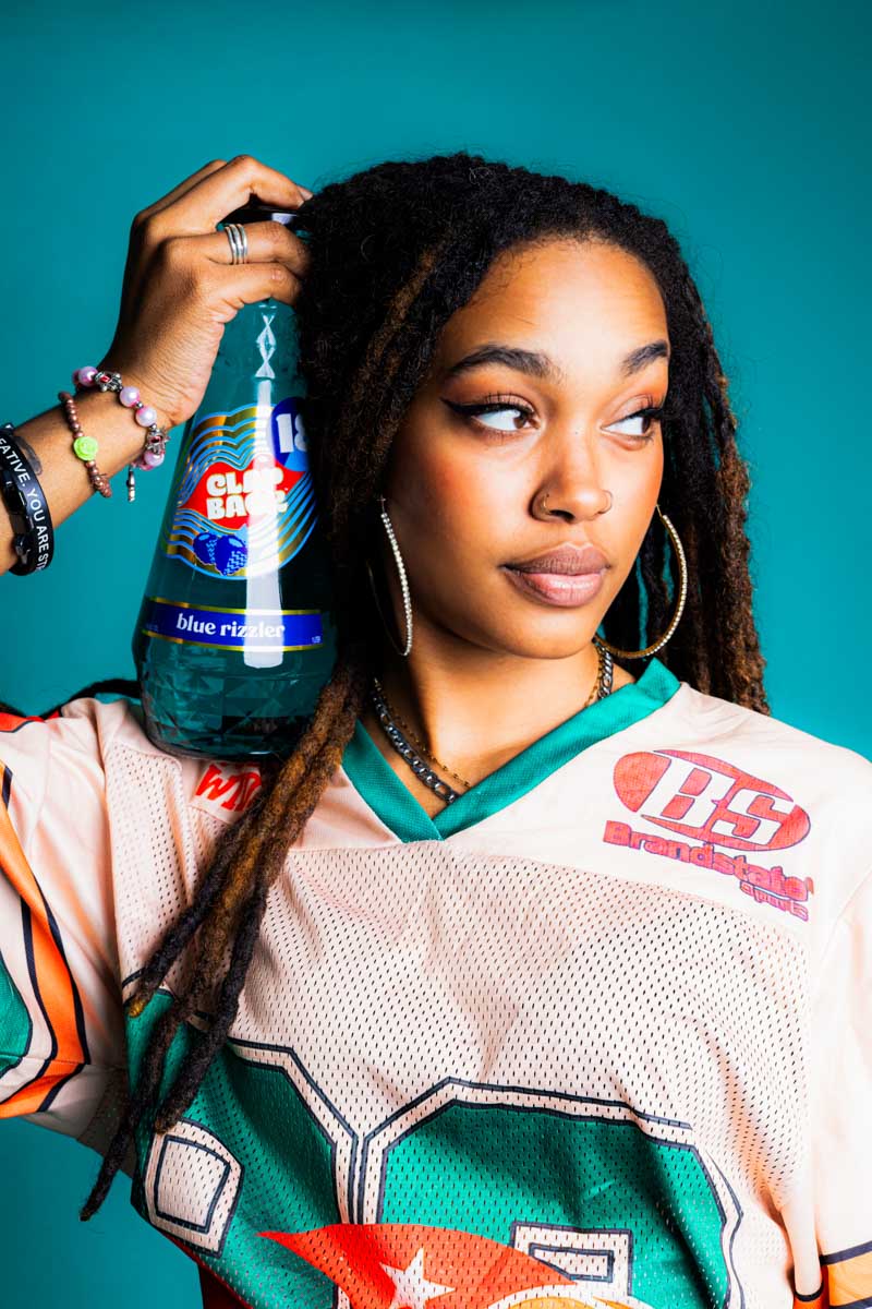 Woman holding a bottle of Clapback - Photo by Jabril Williams